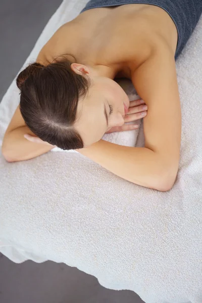 Mujer acostada en una cama esperando un masaje en un spa — Foto de Stock