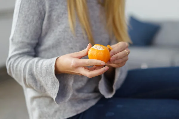 Жінка відриває свіжий апельсиновий фрукт — стокове фото