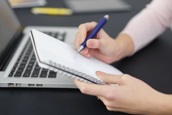 Ufficio donna making alcuni note a suo tavolo — Foto Stock