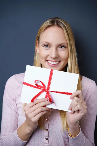 Smiling woman displaying an envelope — Zdjęcie stockowe