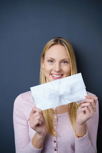 Elated young woman showing a gift envelope — Stock Photo, Image