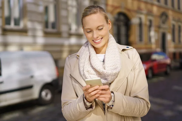Kvinnan Messaging någon via telefon på gatan — Stockfoto