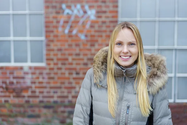 Junge Frau lächelt in der kalten Jahreszeit draußen — Stockfoto