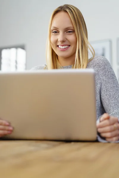 Mulher loira feliz olhando para seu caderno — Fotografia de Stock