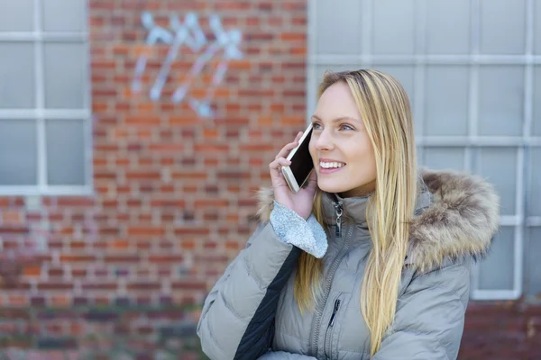 Vrouw die op de straat met behulp van haar mobiele telefoon — Stockfoto