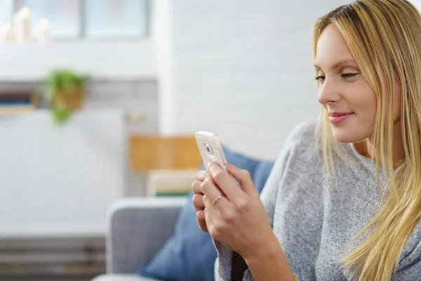 Krásná žena při pohledu na její mobilní telefon — Stock fotografie