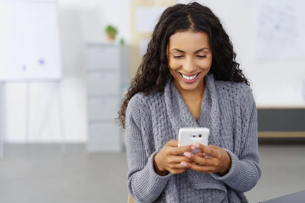 Возбужденная молодая женщина читает смс на мобильном — стоковое фото