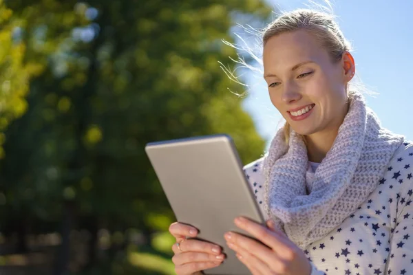 Улыбающаяся женщина читает информацию на планшете — стоковое фото