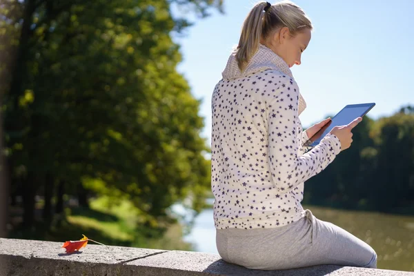 Jonge vrouw vergadering lezing in herfst zon — Stockfoto