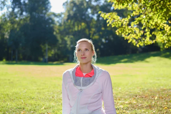 Mujer rubia joven reflexiva al aire libre en un parque — Foto de Stock