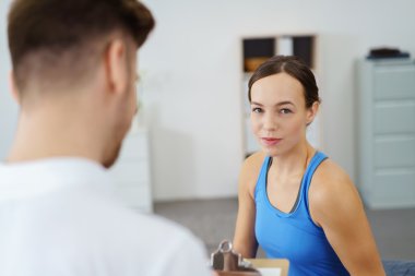 physiotherapist talking to a patient in a physio room. clipart