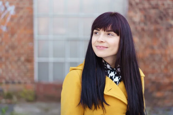 Jeune femme portant un manteau jaune à l'extérieur — Photo