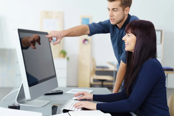 Jovem empresário apontando para um monitor — Fotografia de Stock