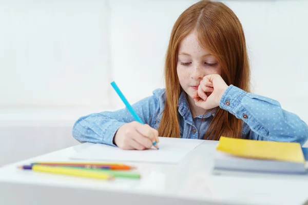 Bonito menina pensativa fazendo lição de casa — Fotografia de Stock