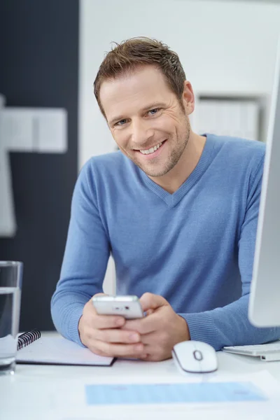 Bonito empresário sentado sorrindo para a câmera — Fotografia de Stock