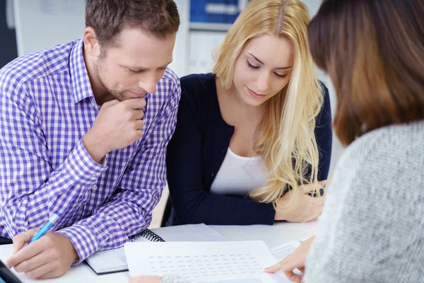 Broker giving a presentation to a young couple — Stock Photo, Image