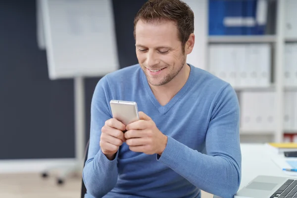 Happy young businessman sending a text message — Stock Photo, Image