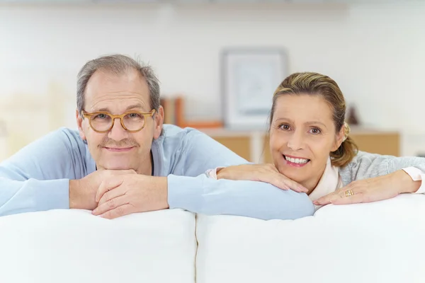 Heureux couple aîné appuyé sur le canapé — Photo