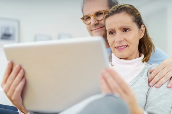 Marido e esposa de meia-idade usando um tablet — Fotografia de Stock