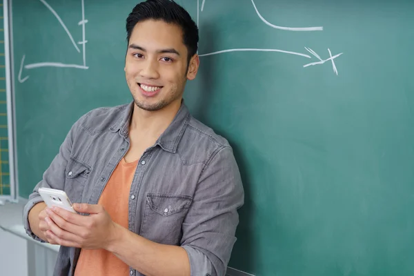Lächelnder junger asiatischer Student mit seinem Handy — Stockfoto