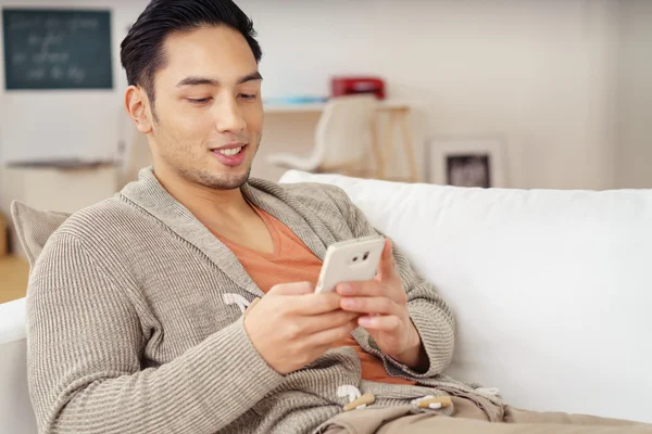 Young Asian man checking for text messages — Stock Photo, Image