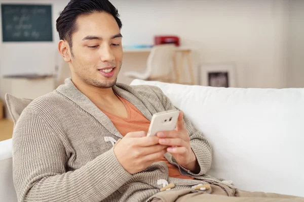 Joven asiático hombre comprobación de mensajes de texto —  Fotos de Stock