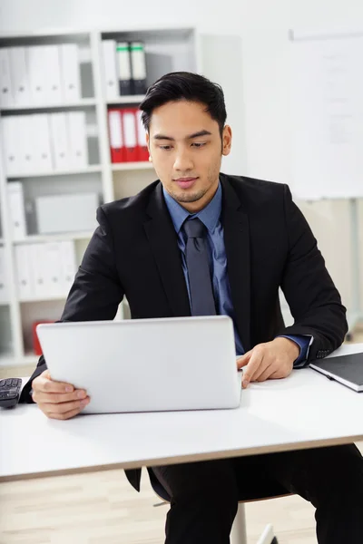 Uomo d'affari che apre il suo computer portatile in ufficio — Foto Stock