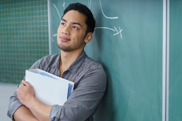 Handsome male student standing daydreaming Royalty Free Stock Photos