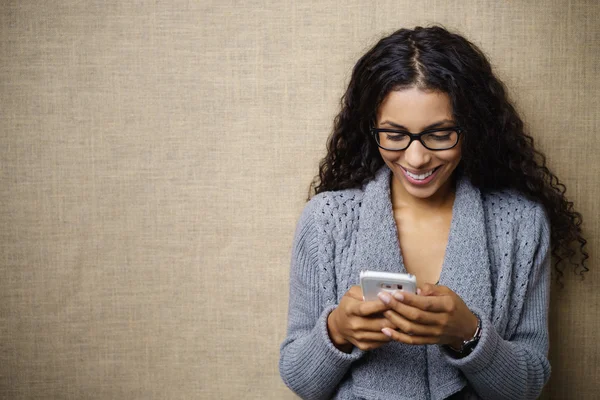 Lächelnde Frau blickt auf Handy herab — Stockfoto