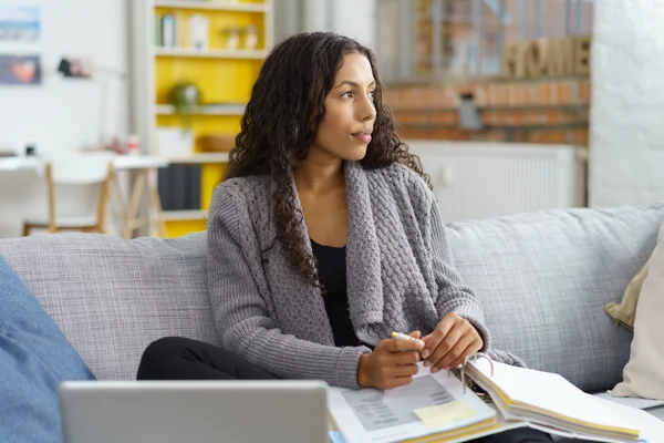 Thoughtful young woman sitting working at home — Stock fotografie