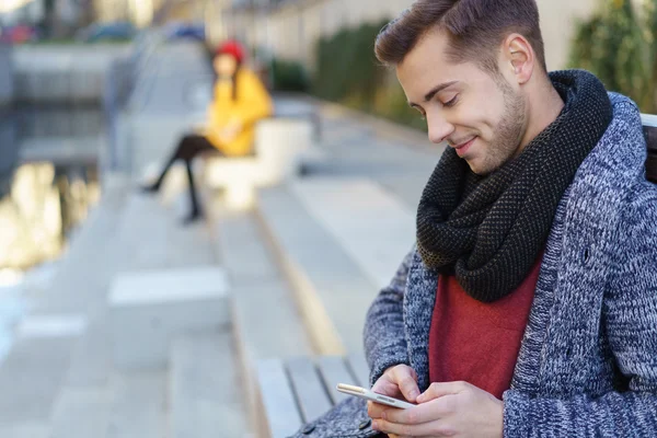 Schöner junger Mann checkt seine SMS — Stockfoto