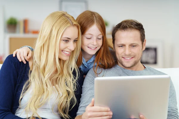 Happy young family using a laptop together — Stock Fotó