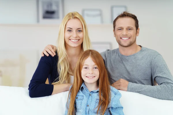 Attractive young family relaxing at home — Stockfoto