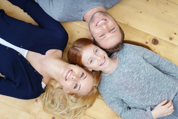 Smiling happy family lying head to head — Stock fotografie