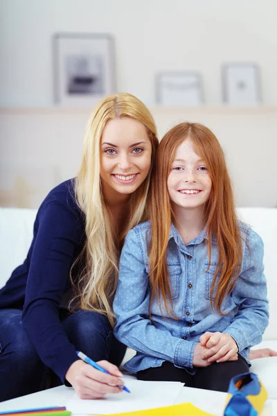 Pretty young Mum and daughter doing homework — 图库照片