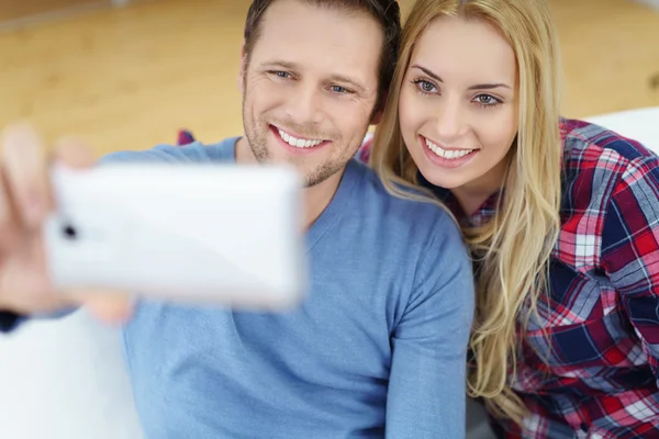 Sorrindo jovem casal tomando uma selfie — Fotografia de Stock