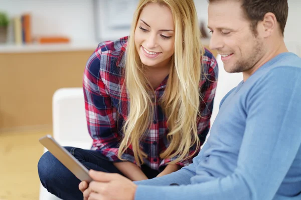 Young couple surfing the internet on a tablet — 스톡 사진