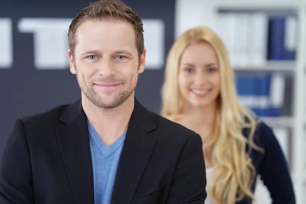 Hombre de negocios sonriente con mujer en la oficina —  Fotos de Stock