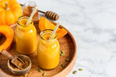 Ahşap tepside küçük şişelerde balkabağı püresi. Sağlıklı beslenme. Vejetaryen yemeği. Mesaj için yer var. Seçici odak