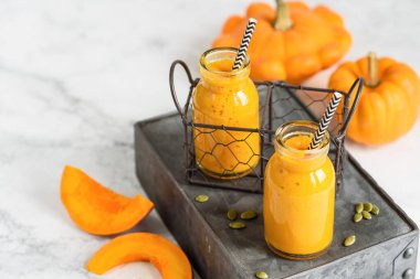 Küçük şişelerde, mermer arka planda balkabağı püresi. Sağlıklı vejetaryen yemekleri. Seçici odak