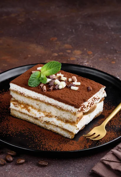 Тирамису Кусок Итальянского Традиционного Десерта Украшенный Мятой Шоколадом Черной Тарелке — стоковое фото