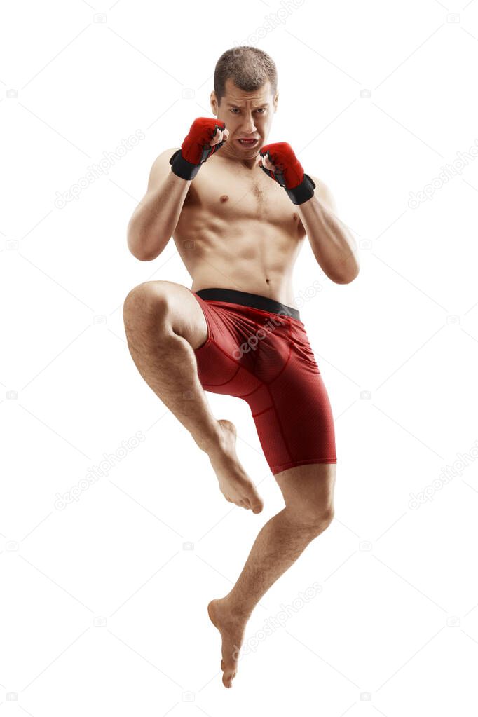 MMA. Jumping knee kick. Male fighter jumping with a knee kick. Straight view. Sport. Isolated