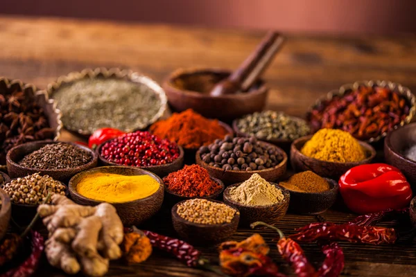 Mesa de madeira de especiarias coloridas — Fotografia de Stock