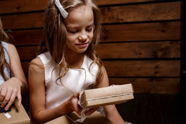 Mutlu kız hediyesini el sanatları paketinde tutuyor. Aile tatili. Mutlu Noeller ve mutlu tatiller! Kapat..