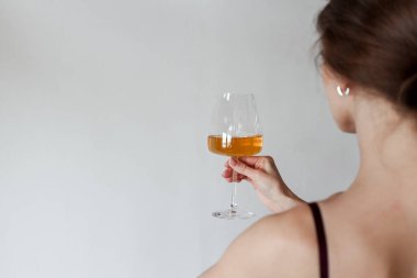 Elinde beyaz şarapla zarif bir kadın. Arkadan bak. Boşluğu kopyala