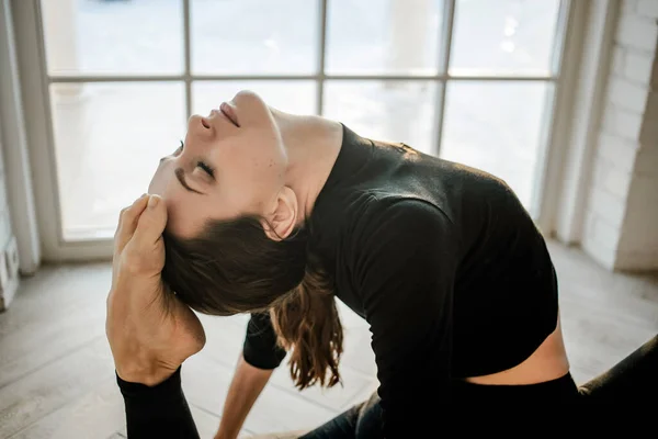 Attractive slim fit yoga girl doing yoga or fitness exercises in a yoga studio. Sport and recreation concept. Healthy lifestyle.