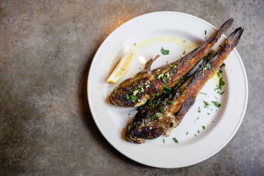 Tabakta kızarmış keçi balığı, yakın plan.