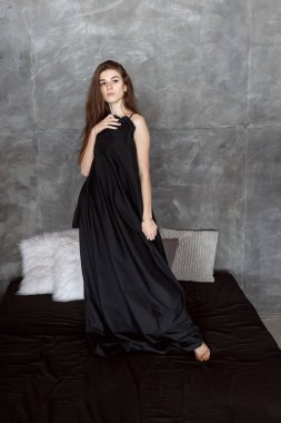 Karanlık odada siyah çarşafa bürünmüş doğal güzel bir kadının portresi. Sağlık, şehvet, insanlar ve güzellik konsepti