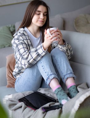 Kadınlar sıcak kanepede kahve ve battaniyeyle oturuyorlar. Kadınlar rahatlar, evde bir fincan çayla sakin bir hayat sürerler.. 