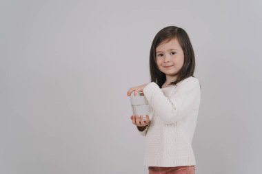 Çocuk bir bardak su tutuyor. Kız su içmek istiyor.